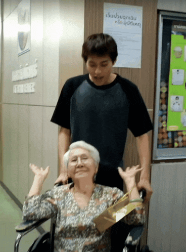 a man stands next to an elderly woman in a wheelchair in front of a sign that says ' nurses '