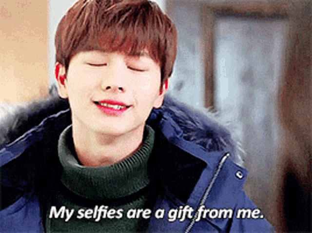 a young man in a blue jacket is smiling and says " my selfies are a gift from me "