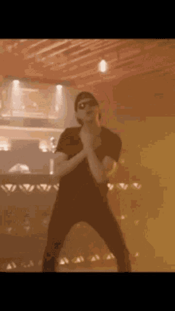 a man is dancing in a dark room with smoke coming out of the ceiling .