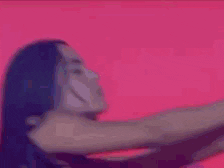 a close up of a woman 's face with a pink background .
