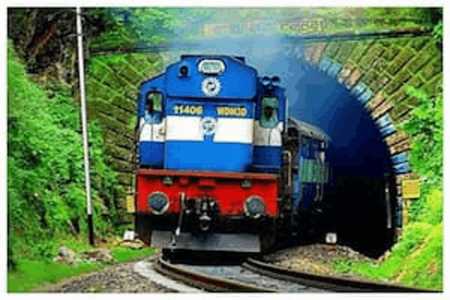 a blue and red train is coming out of a tunnel on the tracks .