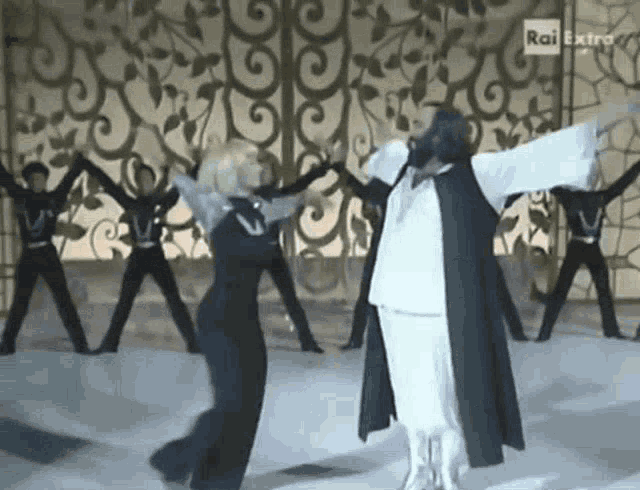 a group of people are dancing in front of a rai extra logo