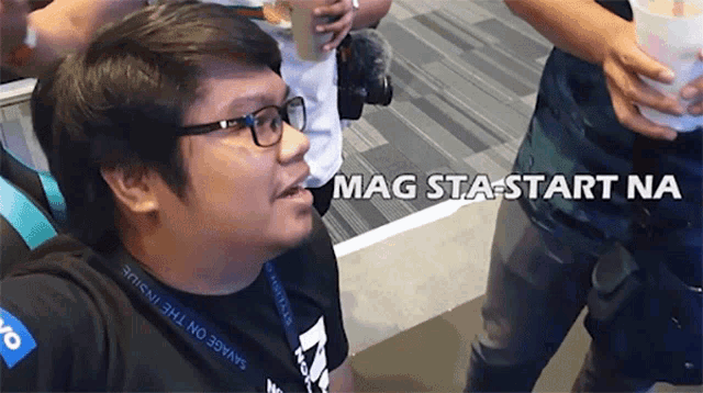 a man wearing glasses and a black shirt that says savage on the inside
