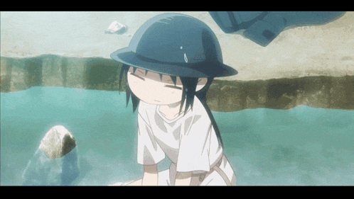 a girl wearing a helmet and a white shirt is sitting in the water