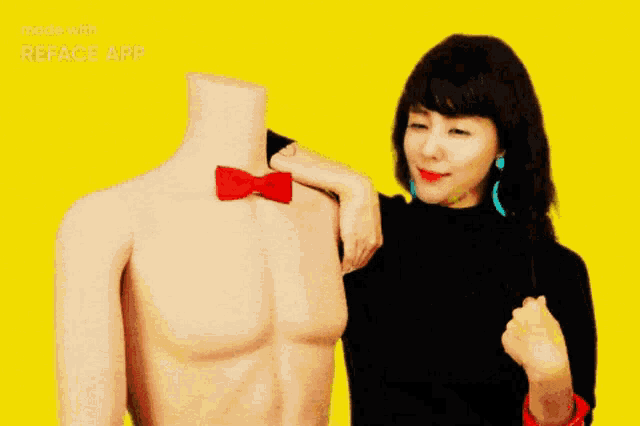 a woman standing next to a mannequin with a red bow tie on it