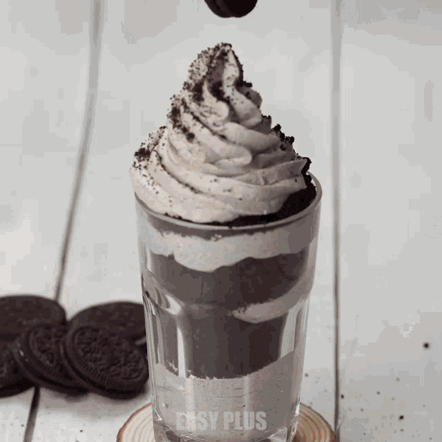 a glass filled with oreo cookies and whipped cream