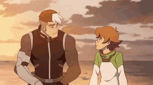 two cartoon characters standing next to each other on a beach .