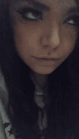 a close up of a woman 's face with a nose ring