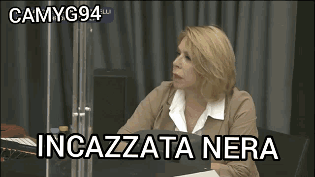 a woman sitting at a table with the words incazzata nera written on the bottom