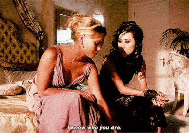 two women are sitting on a bed and one of them says i know who you are