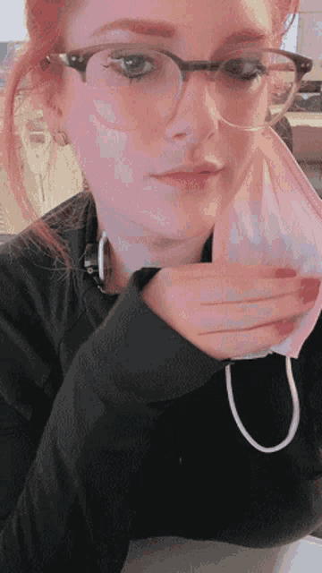 a woman wearing glasses and a pink mask