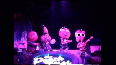 the peach boys are performing on stage in a dark room