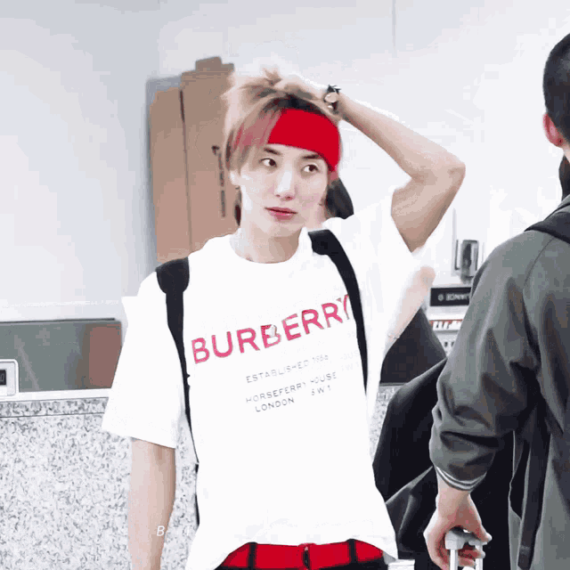 a man wearing a red headband and a white shirt that says burberry