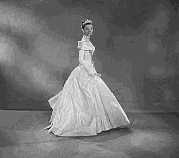 a black and white photo of a woman in a wedding dress .