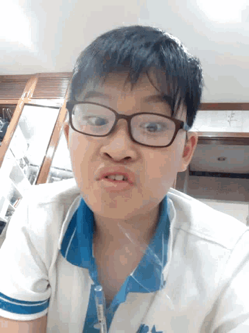 a young boy wearing glasses and a shirt that says ' a ' on it