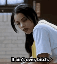 a woman in a white shirt is saying `` it ain 't over , bitch . ''