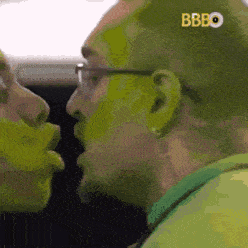 a man with green paint on his face is talking to a woman