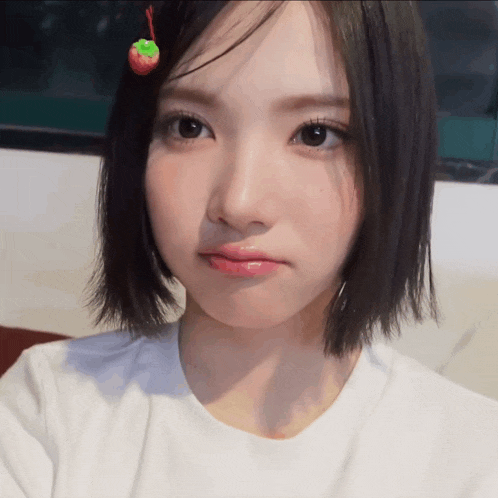 a girl with a strawberry in her hair is making a face