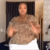 a woman in a leopard print shirt is standing in a room with her hands in the air .