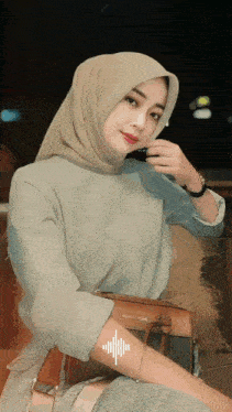 a woman wearing a hijab is holding a purse