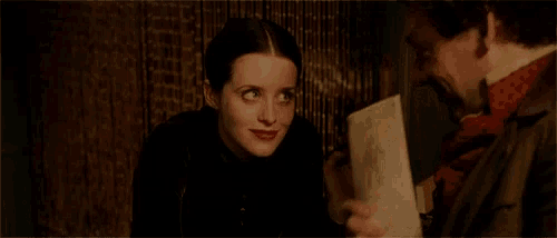 a man is holding a piece of paper and a woman is smiling .