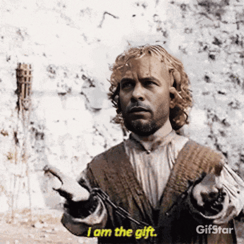 a man with a beard is holding a chain and saying i am the gift