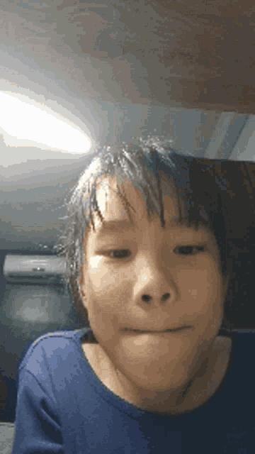 a young boy with wet hair is making a funny face