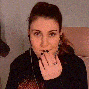 a woman with a ring on her finger is wearing headphones