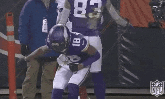 a football player in a purple uniform is kicking a football .