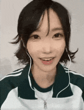 a close up of a girl wearing headphones and a jacket .