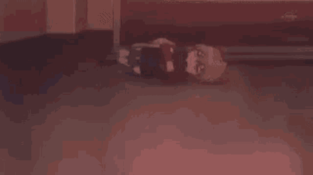 a person is laying on the floor with blood on their clothes .