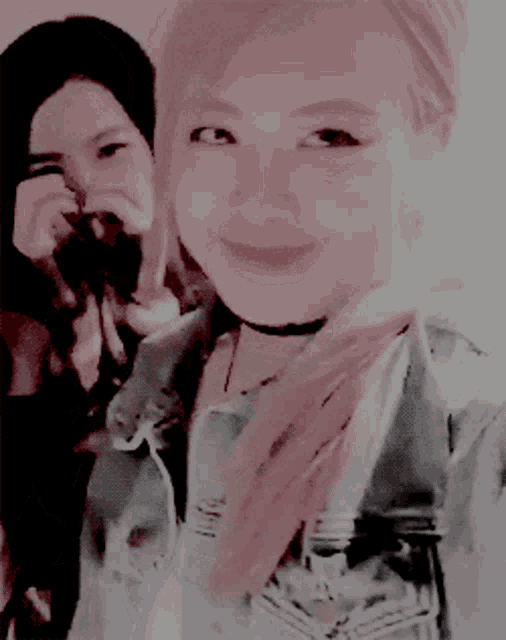 a woman taking a picture of another woman in a pink and black photo