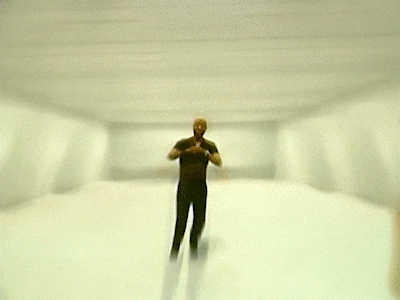 a man in a black shirt is dancing in front of a purple and green background