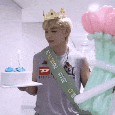 a man wearing a crown is holding a cake and a sash that says ' king '