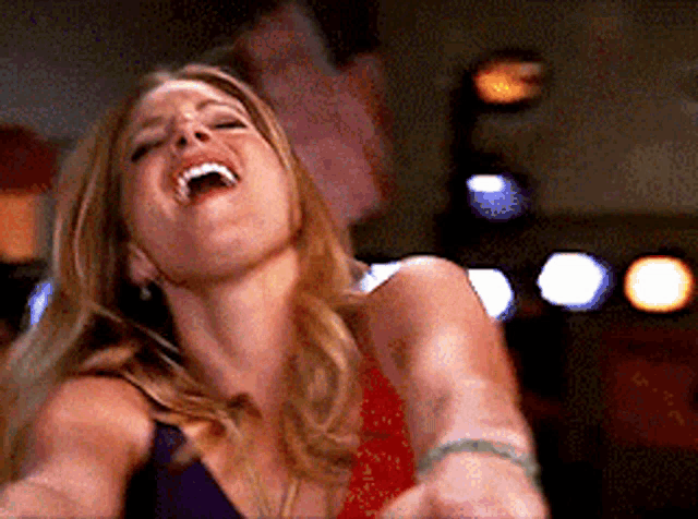 a woman is laughing with her mouth open