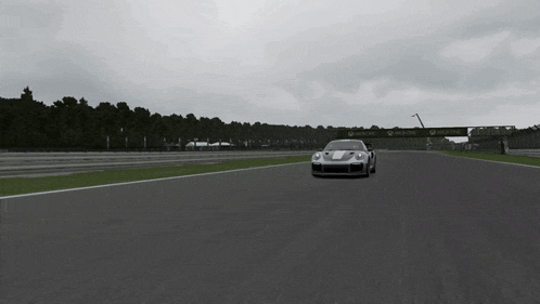 a silver sports car is driving on a track with a sign that says ' allianz ' on it