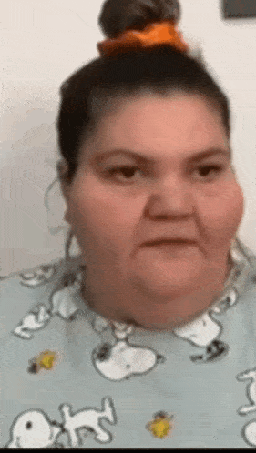 a woman wearing a snoopy shirt has a bun in her hair