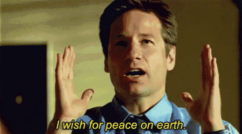 a man in a blue shirt and tie is holding his hands up and saying `` i wish for peace on earth . ''