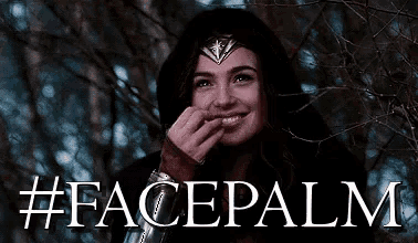 a woman wearing a wonder woman costume is smiling and covering her mouth with her hand .