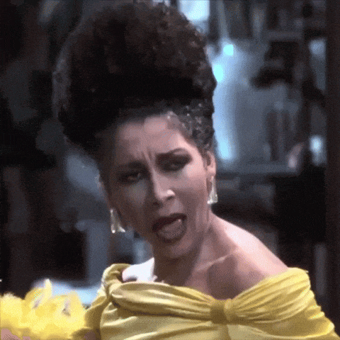 a woman is wearing a yellow dress and making a funny face