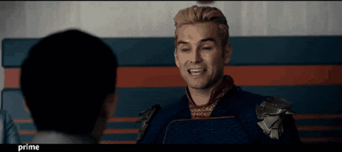a man in a superhero costume is talking to another man with the word prime in the corner