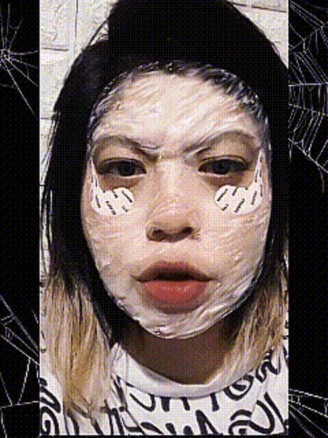 a woman with a white mask on her face is making a face