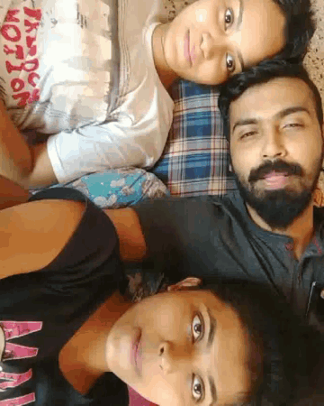 a man with a beard is laying on a bed with two other people