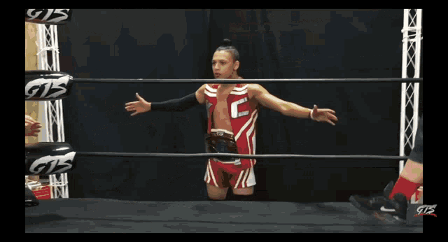 a man in a wrestling ring with gts gloves on his hands