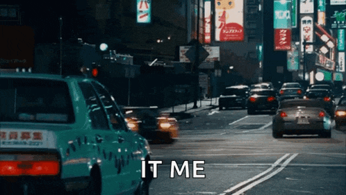 a busy city street at night with a taxi that says it me