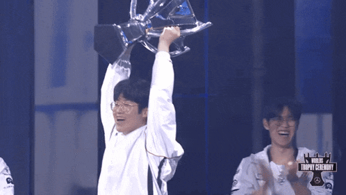 a man holds up a trophy in front of a trophy ceremony sign