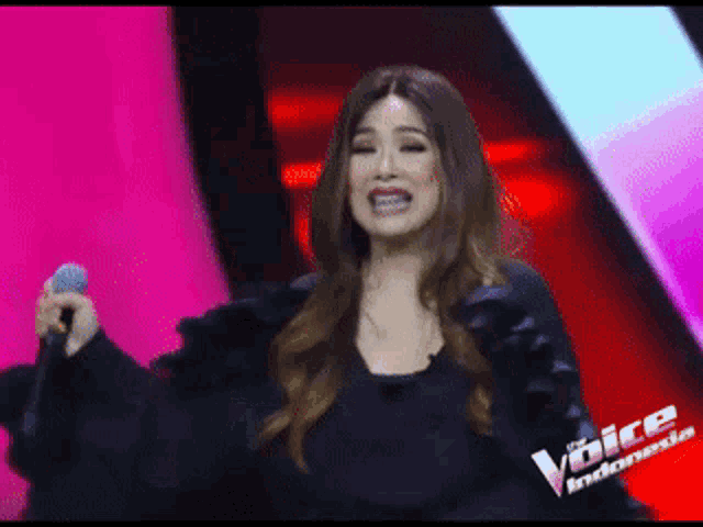 a woman singing into a microphone with the word indonesia on the bottom left