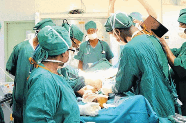 a group of surgeons are operating on a patient in an operating room