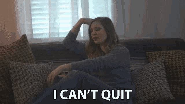 a woman is sitting on a couch with her hand on her head and the words `` i can 't quit '' .