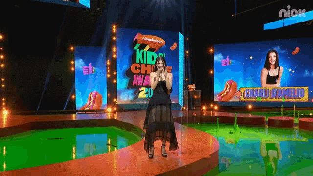 a woman stands on a stage at a nickelodeon kid choice award
